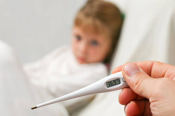 A close-up of a person holding a thermometer stock photo