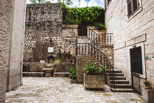 June, 2th, 2016 - Kotor, Montenegro. Stone stairs and flower pots in patio yard on Kotor Old Town.