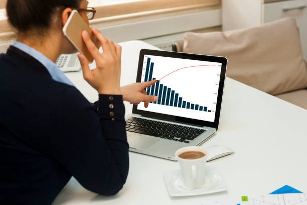 istock Businesswoman working on notebook while talking on phone 945645854