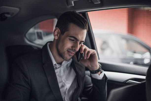 istock Businessman talking on the phone in a car 945646884