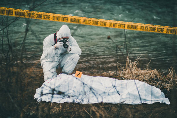 Photographer taking photos of crime scene by the river Photograph on the crime scene evidence photos stock pictures, royalty-free photos & images