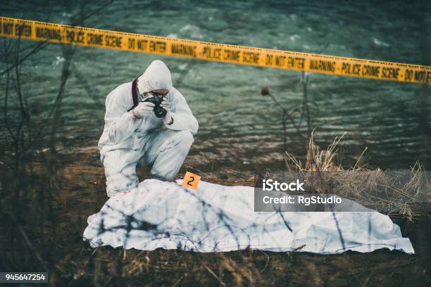 Photographer Taking Photos Of Crime Scene By The River Stock Photo - Download Image Now