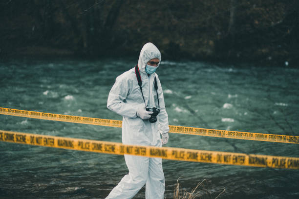 istock Photographer entering crime scene by the river 945647282