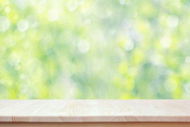 istock Empty wooden countertop on blurred spring background with bokeh. 945650672
