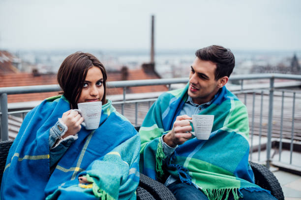 istock Young couple with coffee cups on balcony 945656516