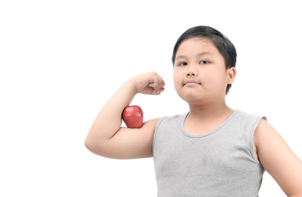 istock Handsome obese fat boy show muscle with apple 945662726