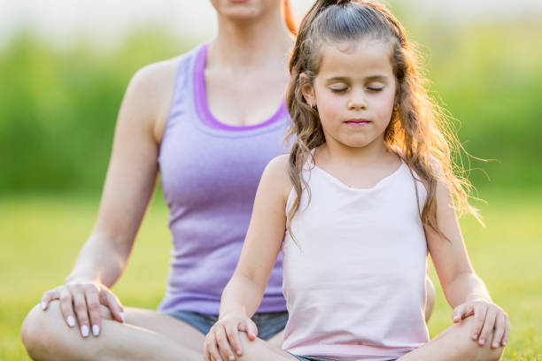 istock Mother And Daughter Meditating Together 945666368