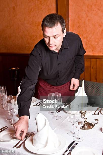 Macho Camarero Le Ofrece Platos En La Mesa En El Restaurante Foto de stock y más banco de imágenes de Ayuda