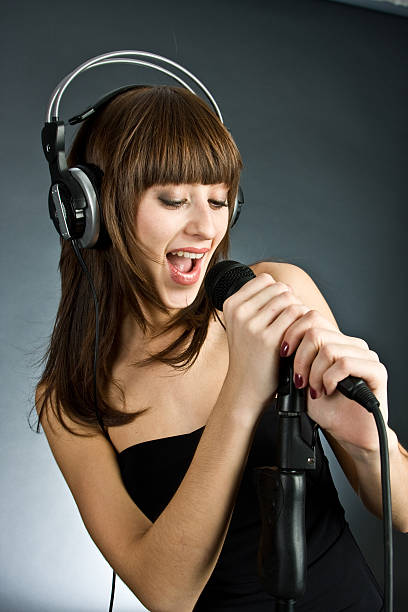 istock Woman in headphones Singing into Microphone 94566965