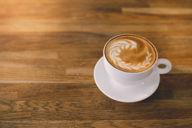 istock A Cup of hot latte art coffee on wooden table 945675138