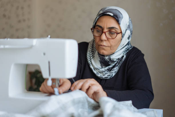 istock Tailor woman working at the sewing machine 945677932