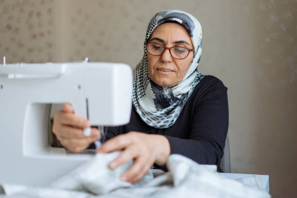 istock Tailor woman working at the sewing machine 945678018