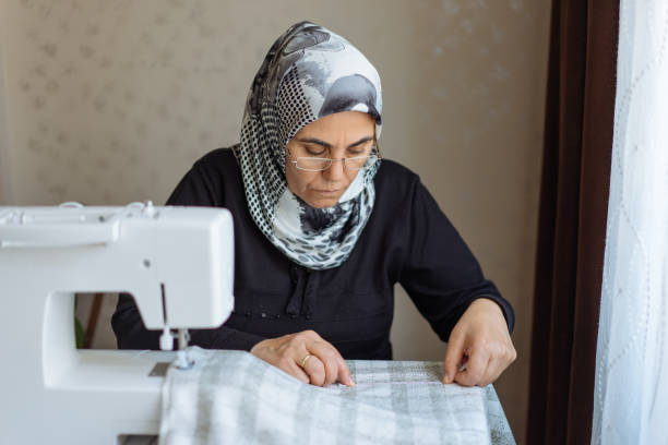 istock Tailor woman working at the sewing machine 945678190