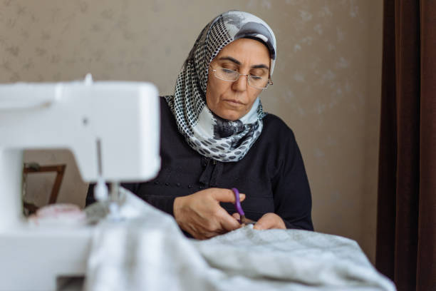 istock Tailor woman working at the sewing machine 945678218