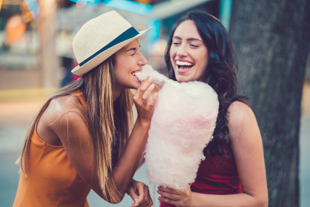 istock Happy women eating pink cotton candy 945678226