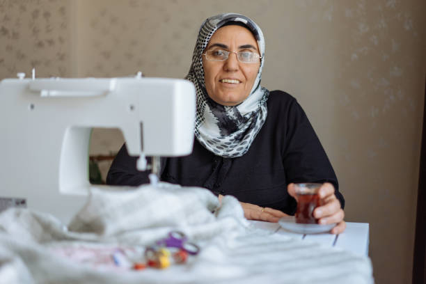 istock Tailor woman working at the sewing machine 945678318