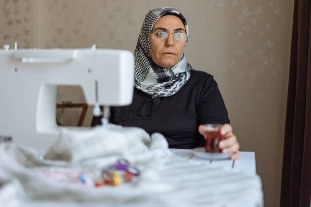 istock Tailor woman working at the sewing machine 945678484