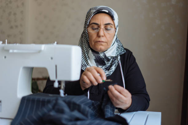 donna sartoriale che lavora alla macchina da cucire - sewing tailor sewing machine women foto e immagini stock