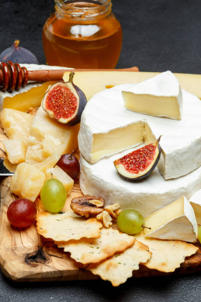 istock Brie cheese on a wooden Board with fresh figs and grapes 945681636