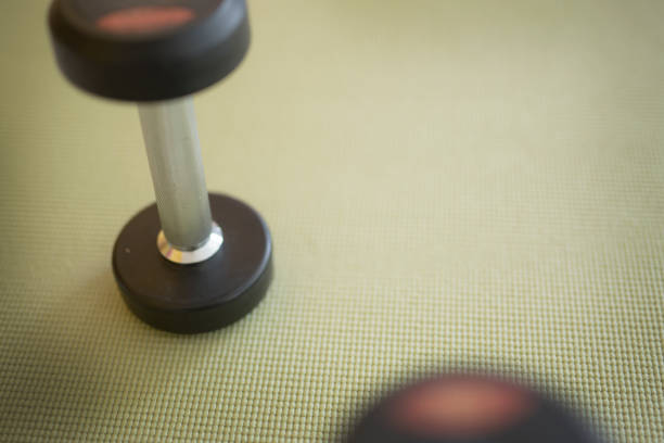 istock Dumbbells Gym with green yoga mat background 945687302