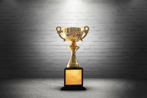 istock Champion golden trophy on wooden table background. copy space. 945689668
