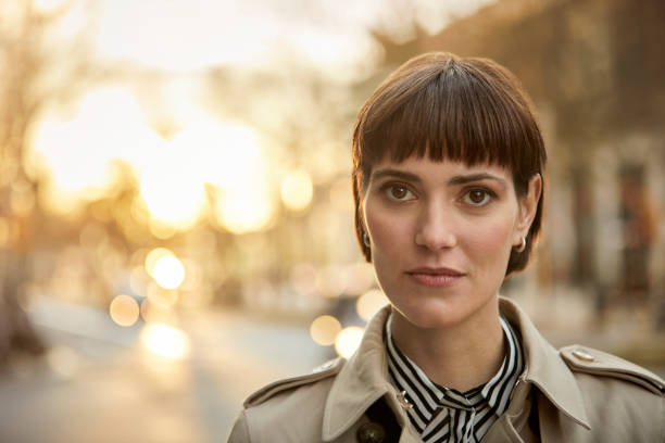 Portrait of confident young businesswoman in city Portrait of confident young businesswoman. Close-up of female professional is with short brown hair. She is in city during sunset. bangs hair stock pictures, royalty-free photos & images