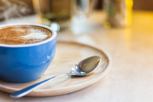 istock Close up coffee cup with steam on table in cafe. 945690620