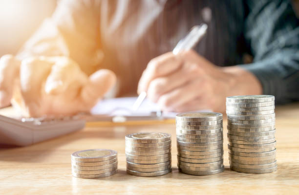 istock Men are Saint documents about save money  with  some coins calculator  on desk. 945696048