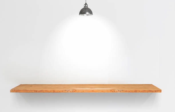 istock Wooden shelf with lamp on white wall. 945696680