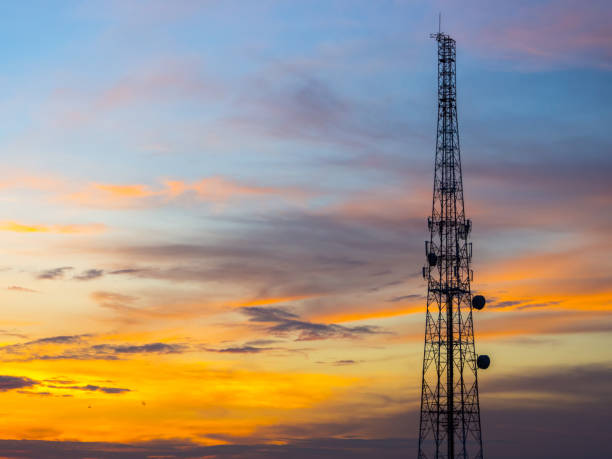 istock Mobile phone communication antenna tower with silhouette in sunset sky background 945713832