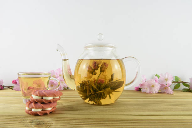 istock glass teapot and cup with flower tea and pink biscuits 945728684