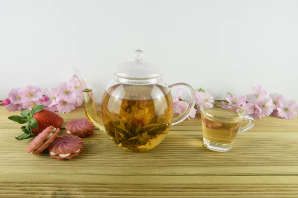 istock glass teapot and cup with flower tea and pink strawberry biscuits 945729668