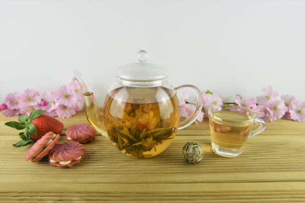 istock glass teapot and cup with flower tea and pink strawberry biscuits 945730074