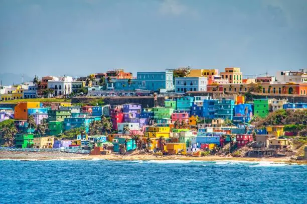 Photo of Bright colorful houses line the hills overlooking the beach in San Juan, Puerto Rico