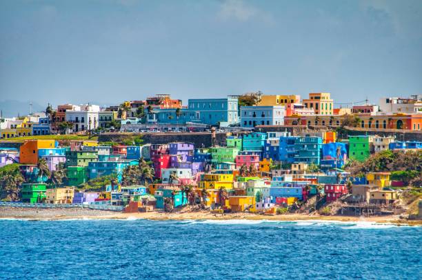 bright colorful houses line the hills overlooking the beach in san juan, puerto rico - old san juan imagens e fotografias de stock