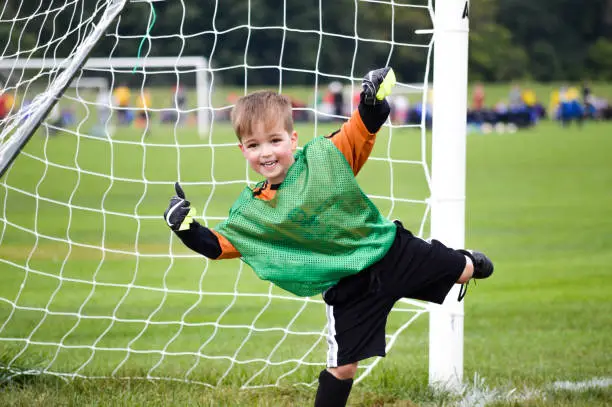 Boy playing youth soccer outdoors on a soccer field.