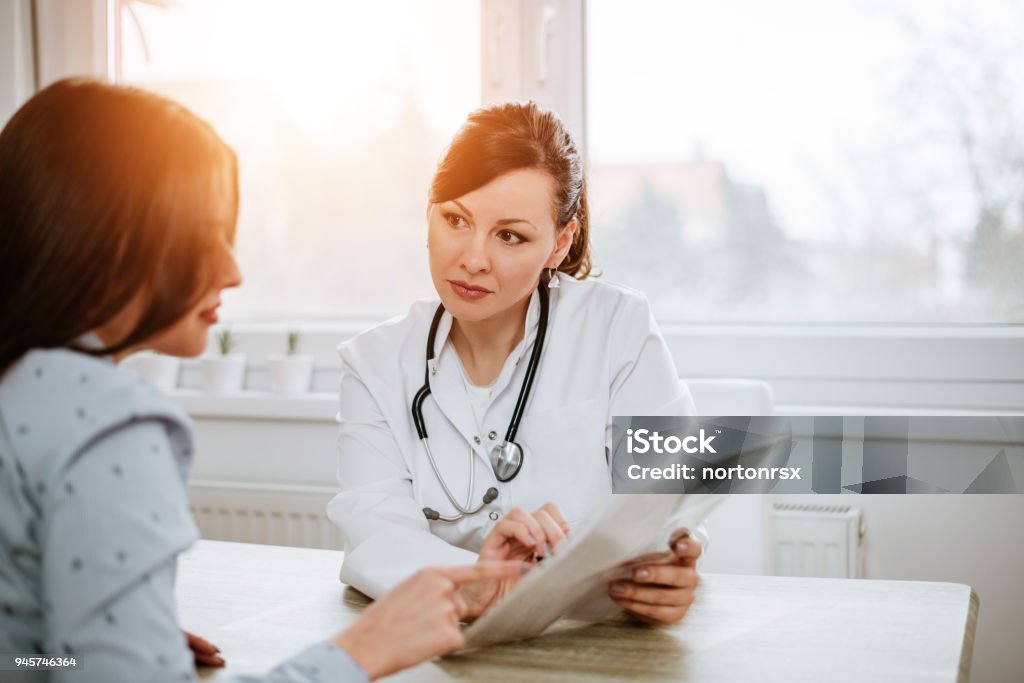 Healthcare and medicine concept. Beautiful female doctor explaining results to her patient. Doctor Stock Photo