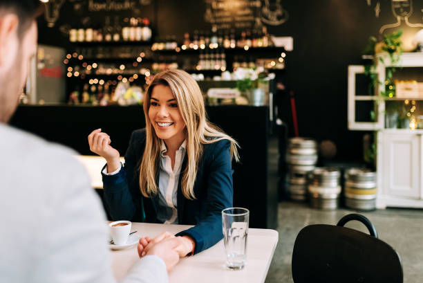 istock Woman holding man's hand while sitting at the cafe. 945746536