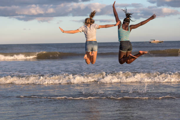 Synchronize jump by the sea sunset time wave jumping stock pictures, royalty-free photos & images