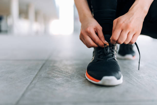 istock Tying shoelace, indoors. Close-up. 945748136