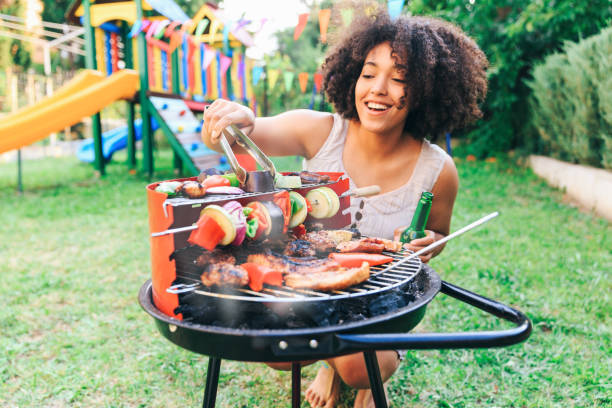 istock Smiling woman preparing barbecue at backyard 945769888