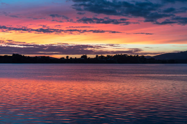 istock Intense sunrise reflects red on water 945772840