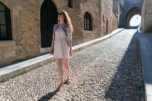 Young caucasian woman walking down the Street of the Knights in Rhodes town - Rhodes island, Greece.