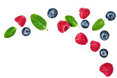 Fresh  raspberries and blueberries with leaves isolated on white background. Berry ornament