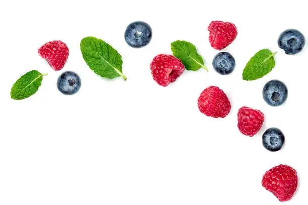 Photo of Fresh  raspberries and blueberries with leaves isolated on white background. Berry ornament