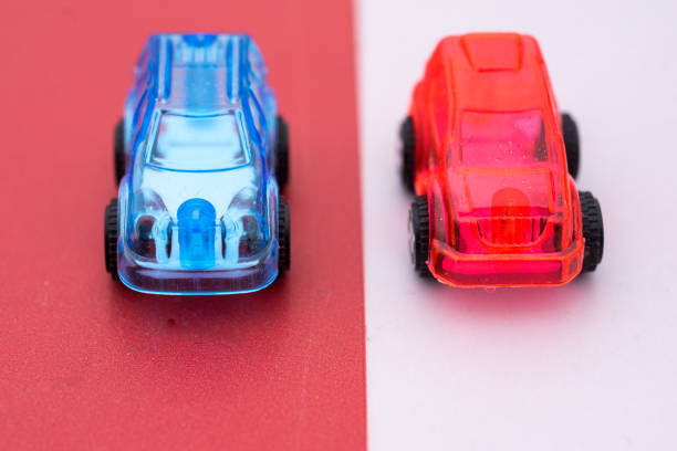 istock contrasting red and white plastic cars on opposite tracks 945814054