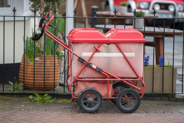 istock red mail cart locked to gate on sidewalk in the UK 945814056