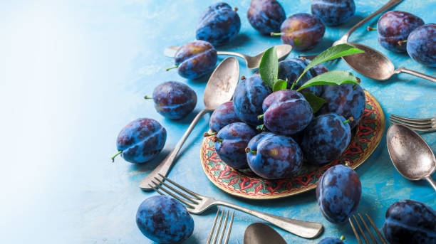 istock Plums and leaves arrangement on plate with forks and spoons 945817412