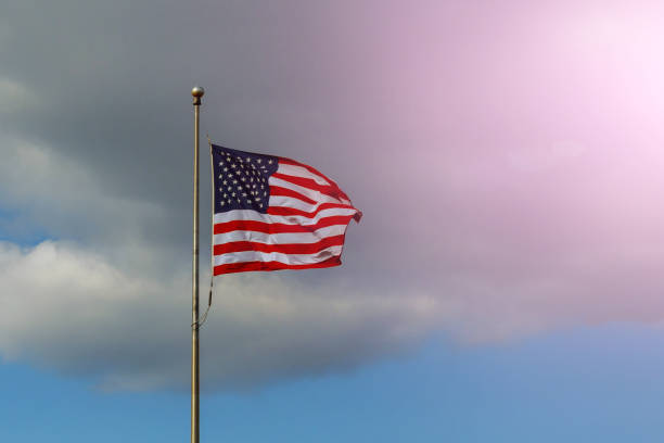 istock The USA flag on a cloudy sky background 945820046