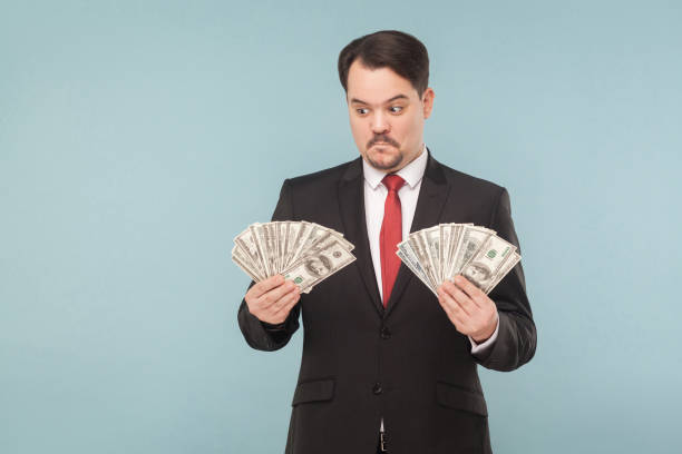 istock Man in stress holding many dollars 945824810